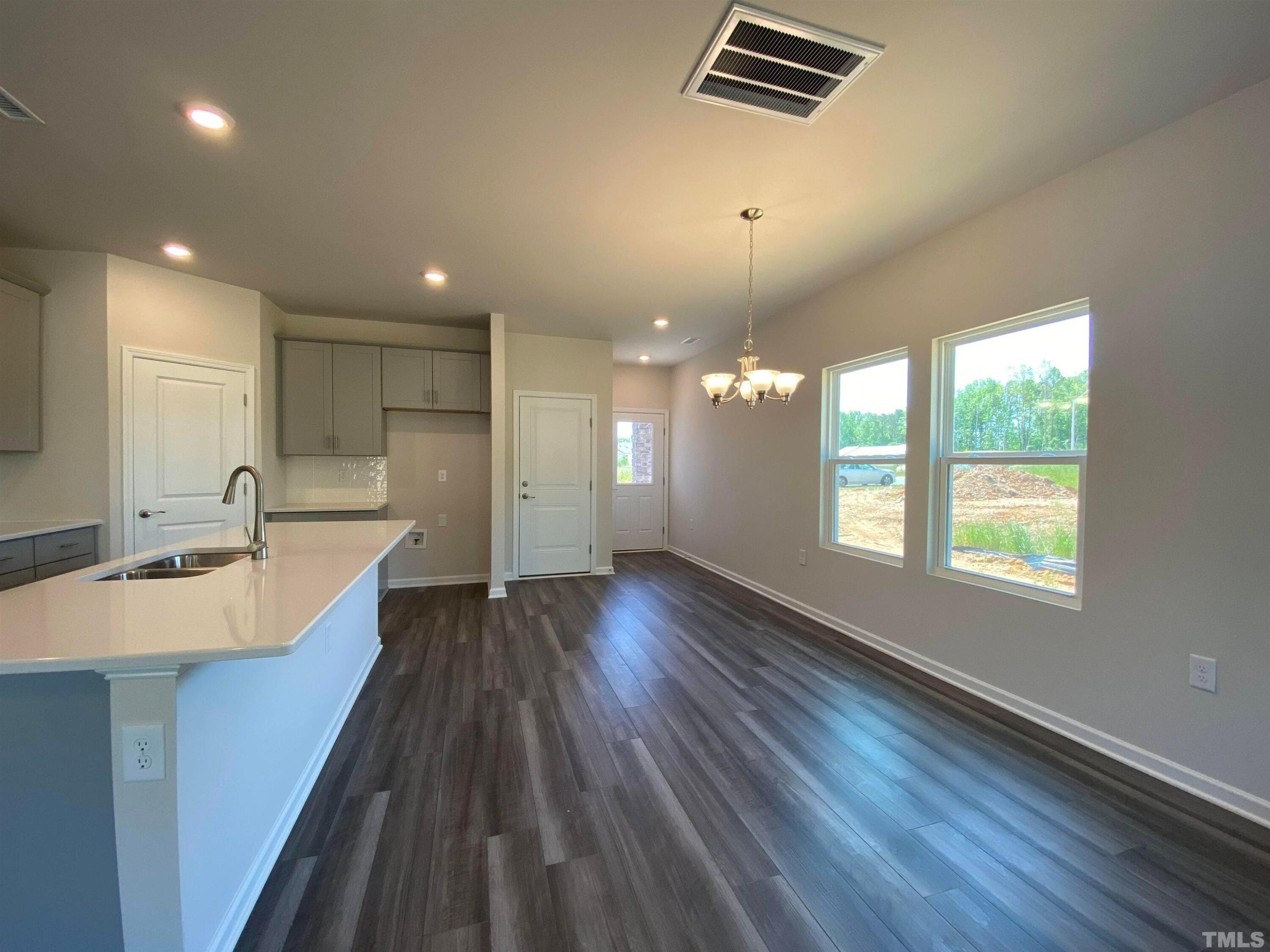 908 Clearhaven Lane Fuquay-Varina, NC 27526 - Photo 4 of 23 a large kitchen with kitchen island a large island wooden floor and stainless steel appliances