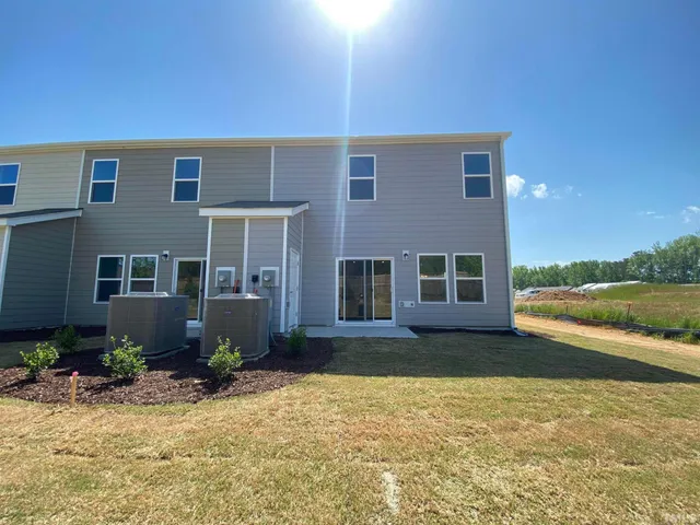 a view of a house with a yard and a ceiling fan