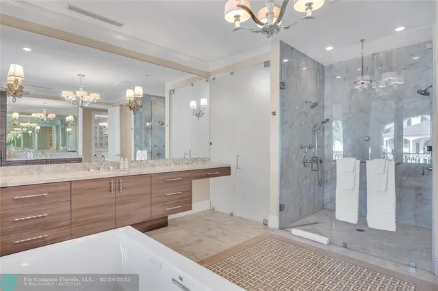 a bathroom with a sink a large mirror and shower
