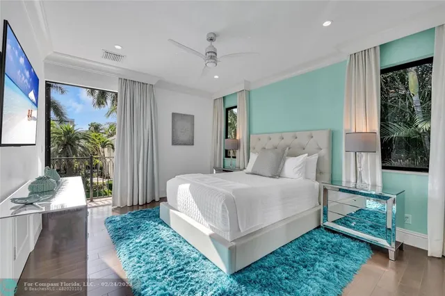 a bedroom with a large bed and windows