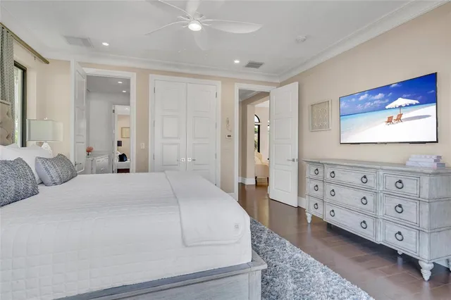 a spacious bedroom with a bed and a flat screen tv