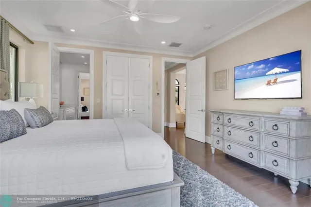a spacious bedroom with a bed and a flat screen tv