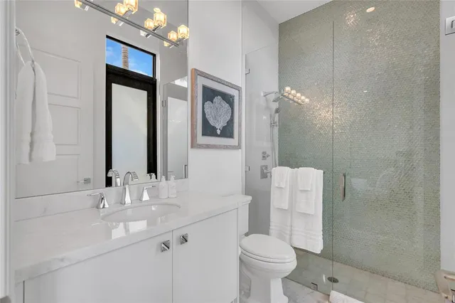 a bathroom with a double vanity sink mirror and toilet