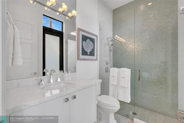 a bathroom with a double vanity sink mirror and toilet