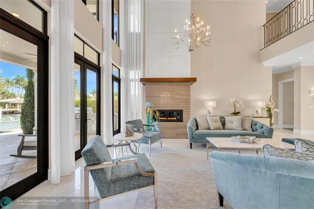 a living room with furniture a fireplace and a chandelier