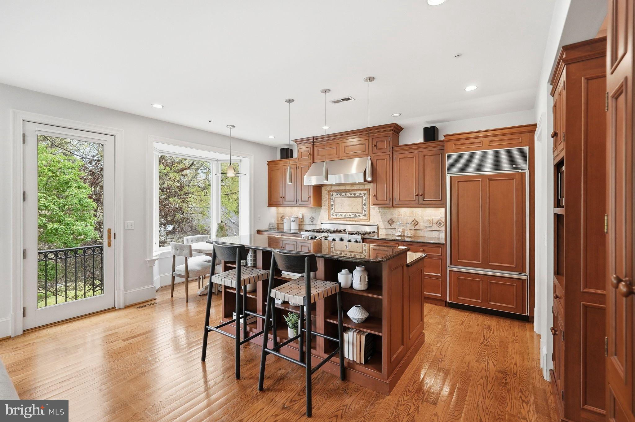 2318 Nebraska Avenue Northwest Washington, DC 20016 - Photo 5 of 28 a kitchen with stainless steel appliances granite countertop a dining table chairs and wooden floors