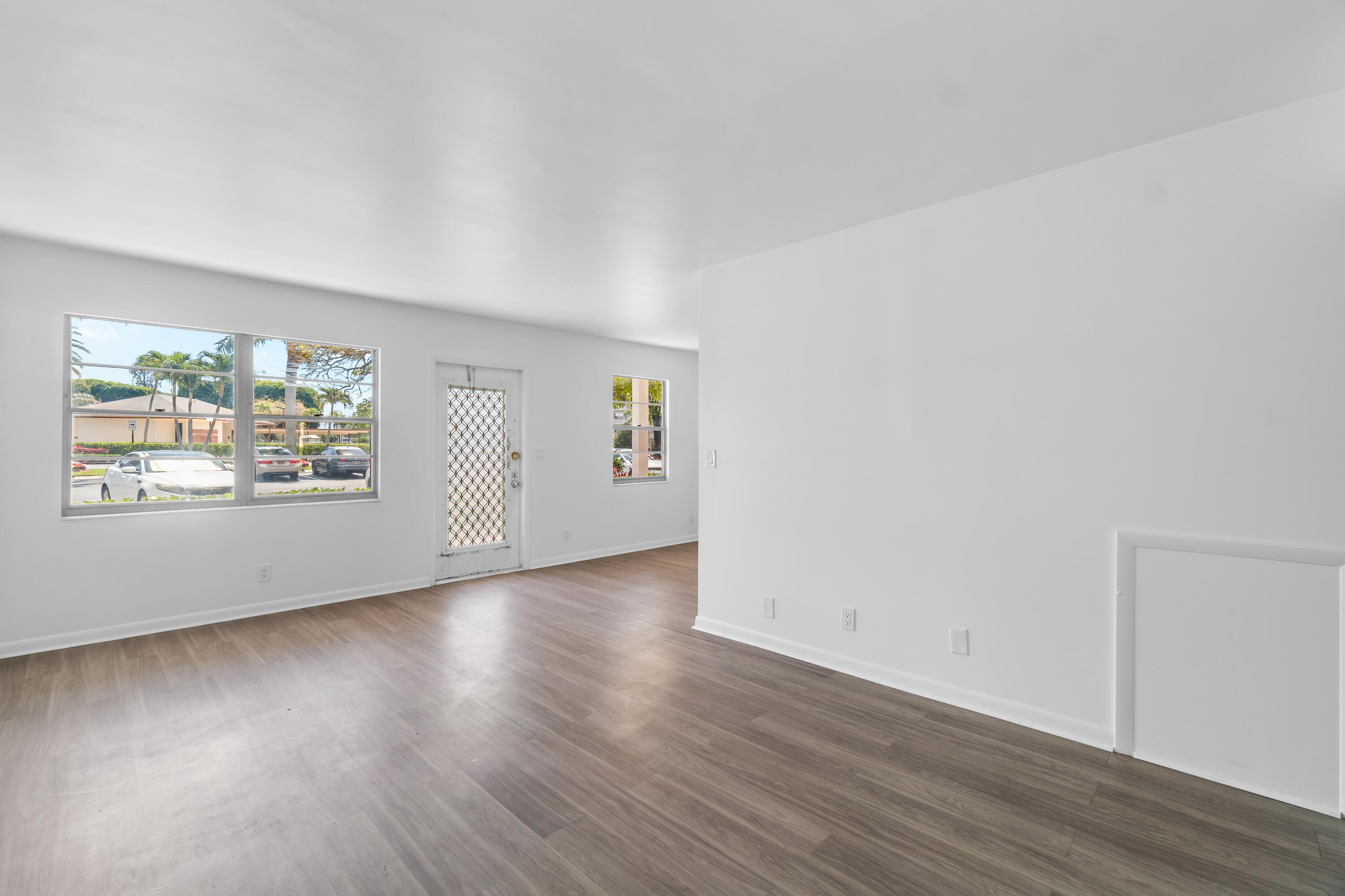 1007 Rexford Drive, Unit 1007 Boca Raton, FL 33434 - Photo 2 of 21 an empty room with wooden floor and window