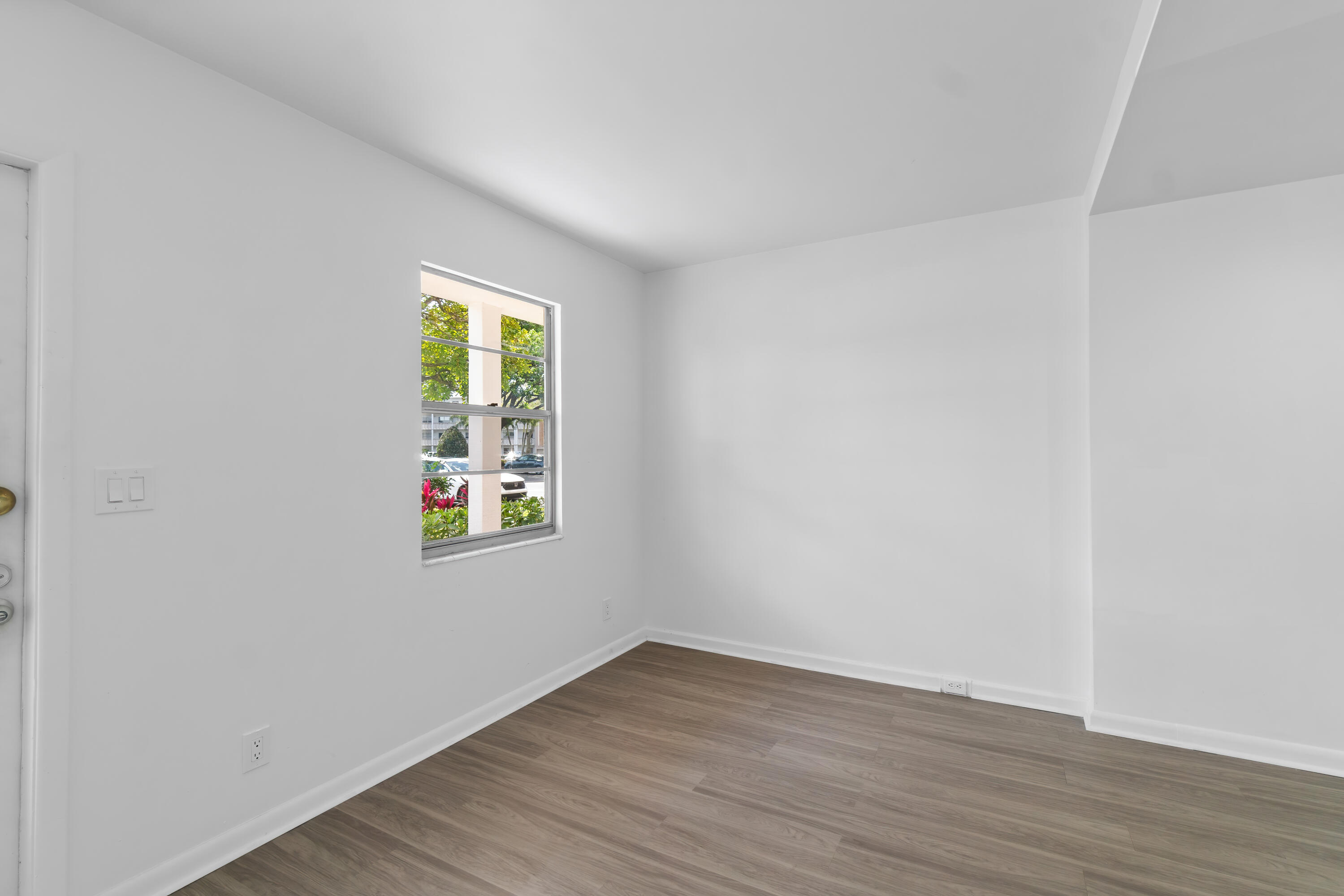 1007 Rexford Drive, Unit 1007 Boca Raton, FL 33434 - Photo 5 of 21 an empty room with wooden floor and windows