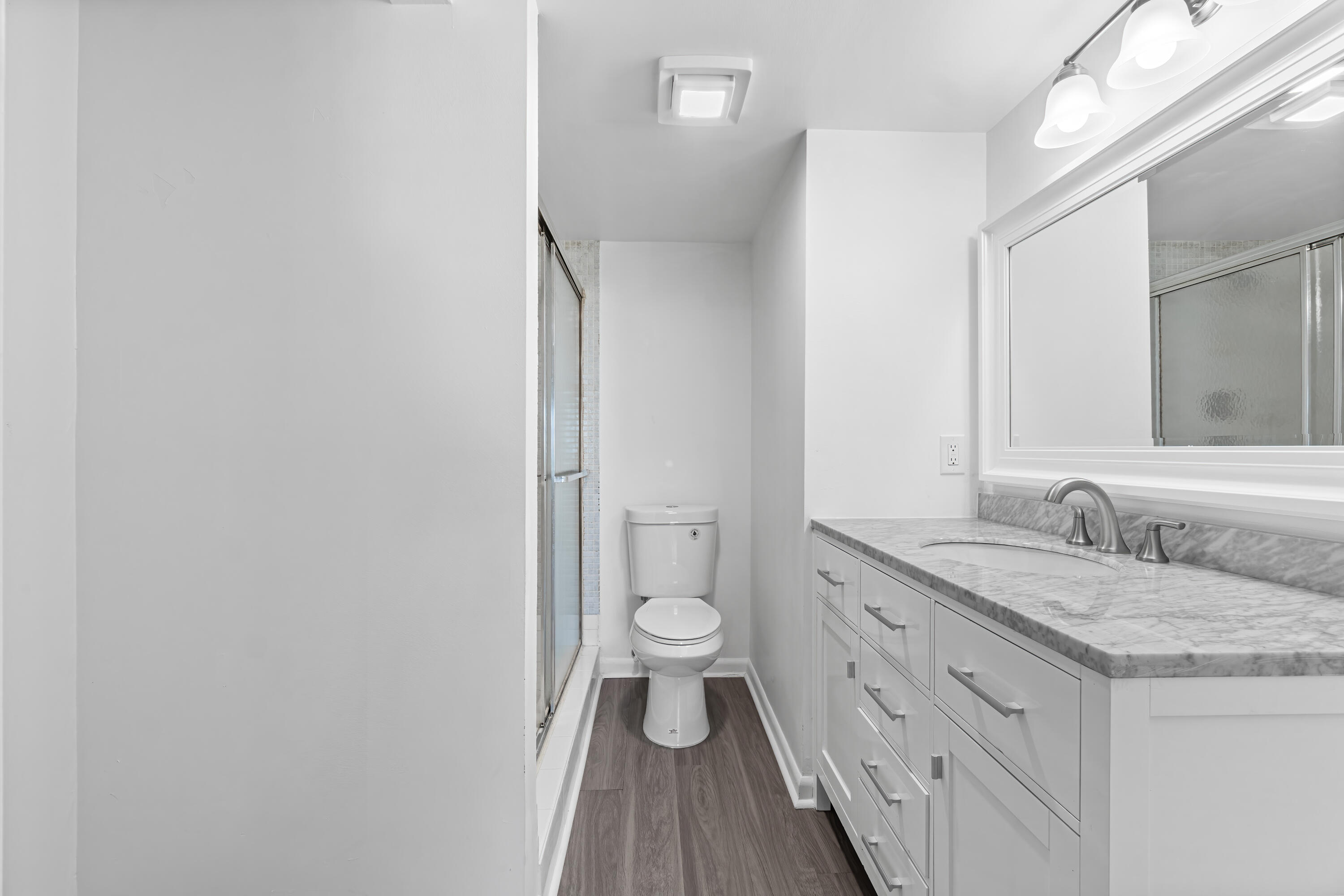 1007 Rexford Drive, Unit 1007 Boca Raton, FL 33434 - Photo 10 of 21 a bathroom with a granite countertop double vanity sink a mirror and a toilet