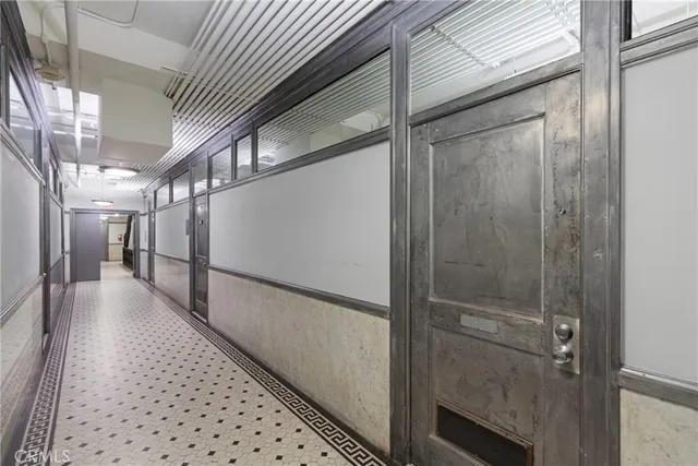 a hallway with wooden floor and staircase