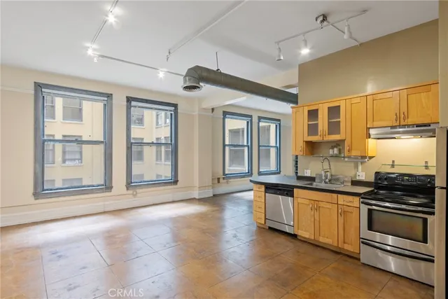 a view of a kitchen with stainless steel appliances granite countertop a stove and a sink