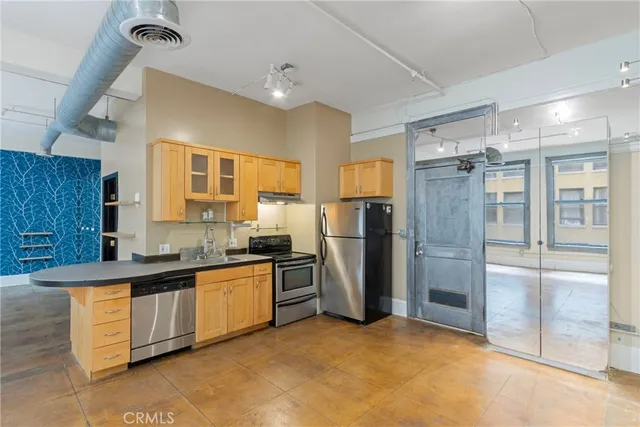 a kitchen with stainless steel appliances granite countertop a refrigerator a sink and a stove