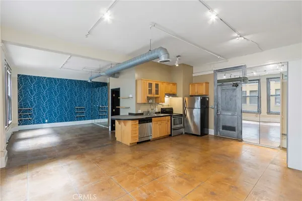 a large white kitchen with a large window and stainless steel appliances