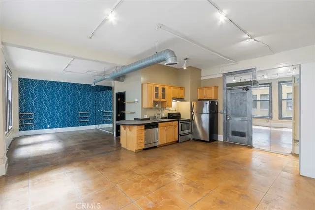 a large white kitchen with a large window and stainless steel appliances