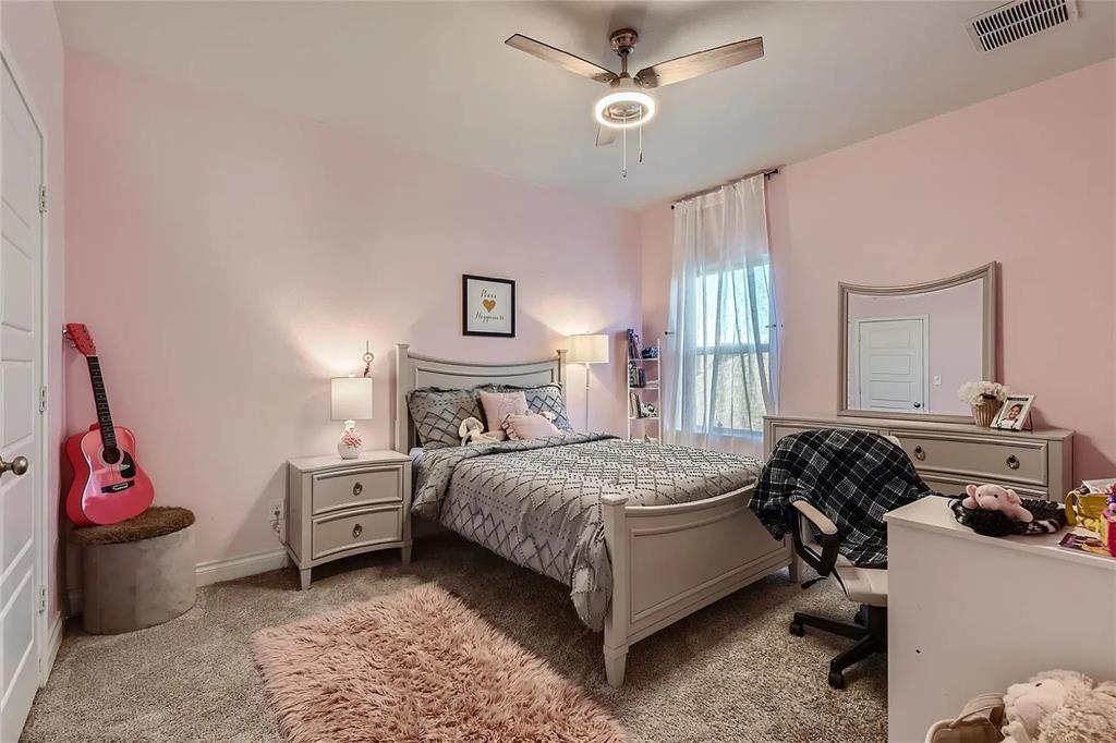 242 Freeman Loop Liberty Hill, TX 78642 - Photo 17 of 27 a bedroom with a bed and a chandelier