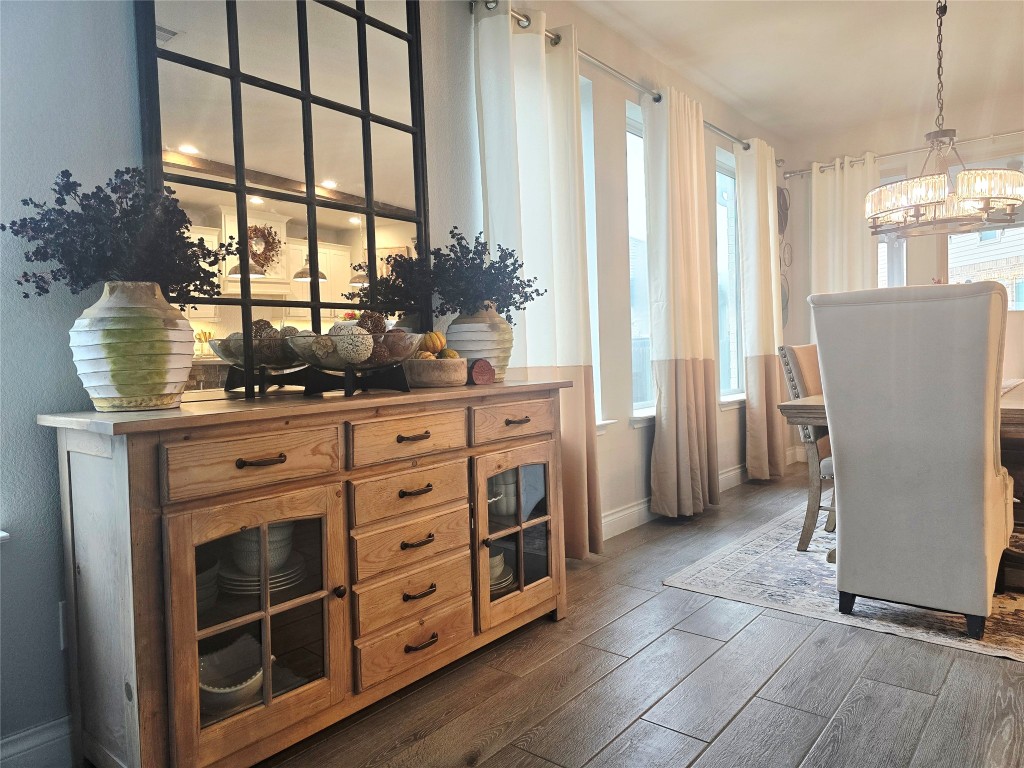 242 Freeman Loop Liberty Hill, TX 78642 - Photo 2 of 25 Dining area with wood look finish floors and wood baseboards