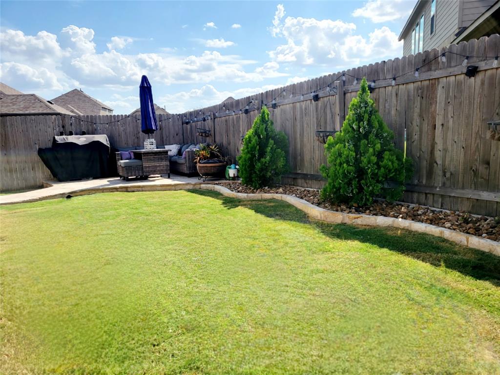 242 Freeman Loop Liberty Hill, TX 78642 - Photo 21 of 27 a view of a swimming pool with a yard and plants