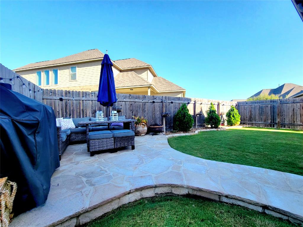 242 Freeman Loop Liberty Hill, TX 78642 - Photo 21 of 25 Fenced backyard with an outdoor hangout area and a patio