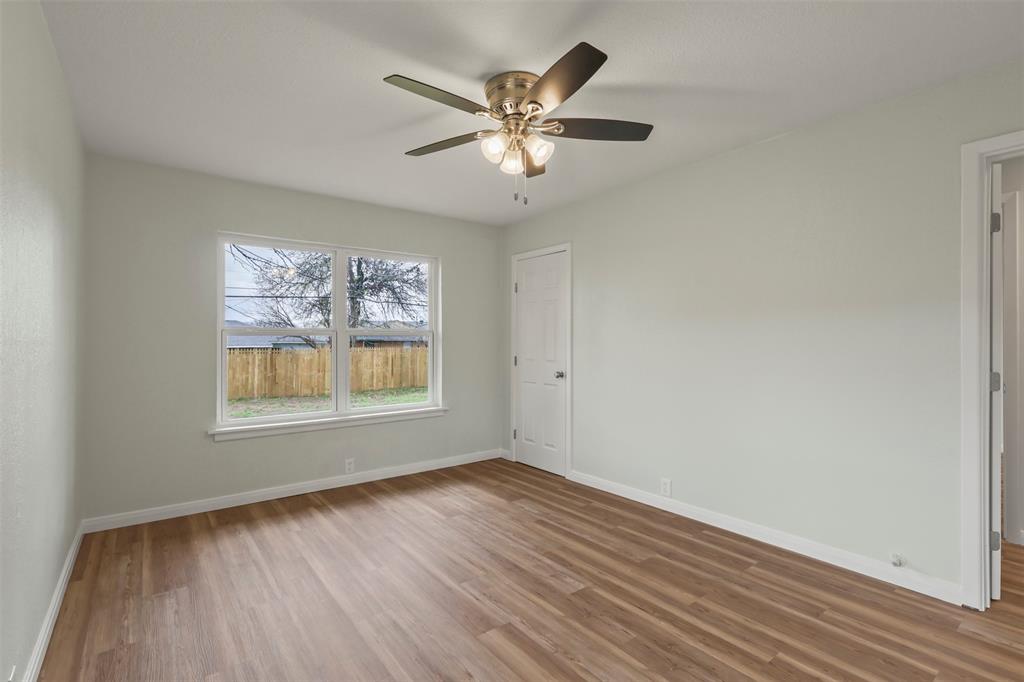 732 Bullock Street Denison, TX 75020 - Photo 17 of 29 an empty room with wooden floor and windows