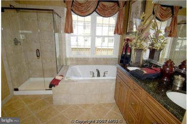 7663 Elmcrest Road Hanover, MD 21076 - Photo 5 of 9 a bathroom with a granite countertop tub sink and mirror