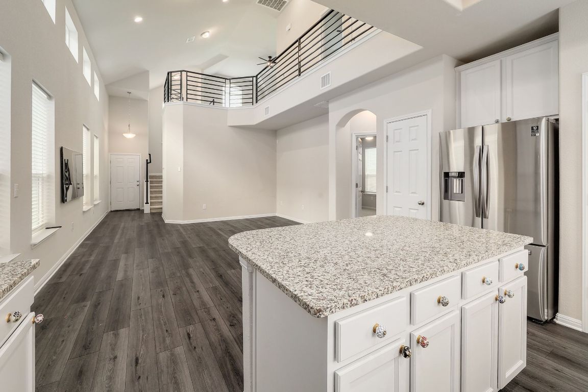 10709 Blacket Drive Austin, TX 78747 - Photo 27 of 27 a kitchen with stainless steel appliances kitchen island granite countertop a wooden floor and white cabinets