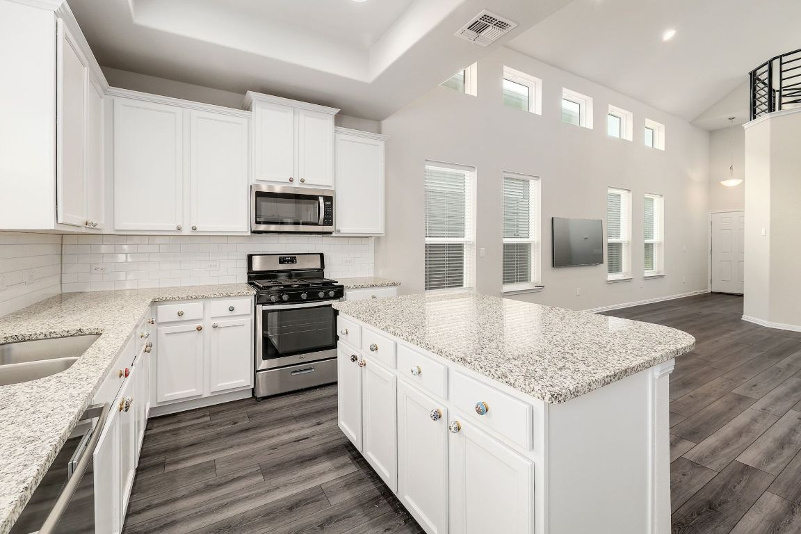10709 Blacket Drive Austin, TX 78747 - Photo 9 of 27 a kitchen with granite countertop white cabinets and stainless steel appliances