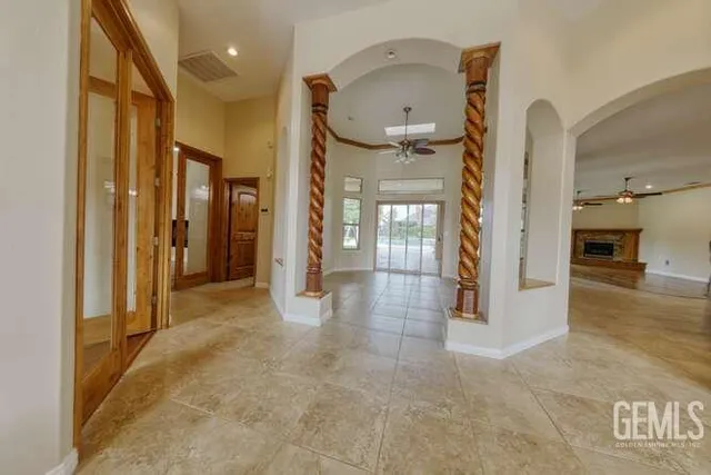 a view of a hallway with wooden floor and a living room