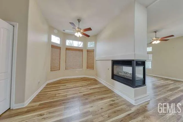 a view of an empty room with a fireplace and a window