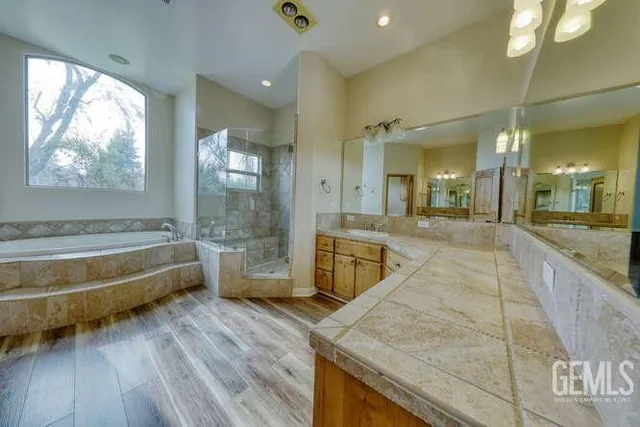 a bathroom with a tub a sink and a large mirror