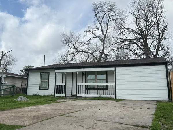 a view of a house with a yard and large tree