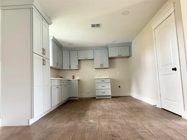 a view of a kitchen with cabinets and wooden floor