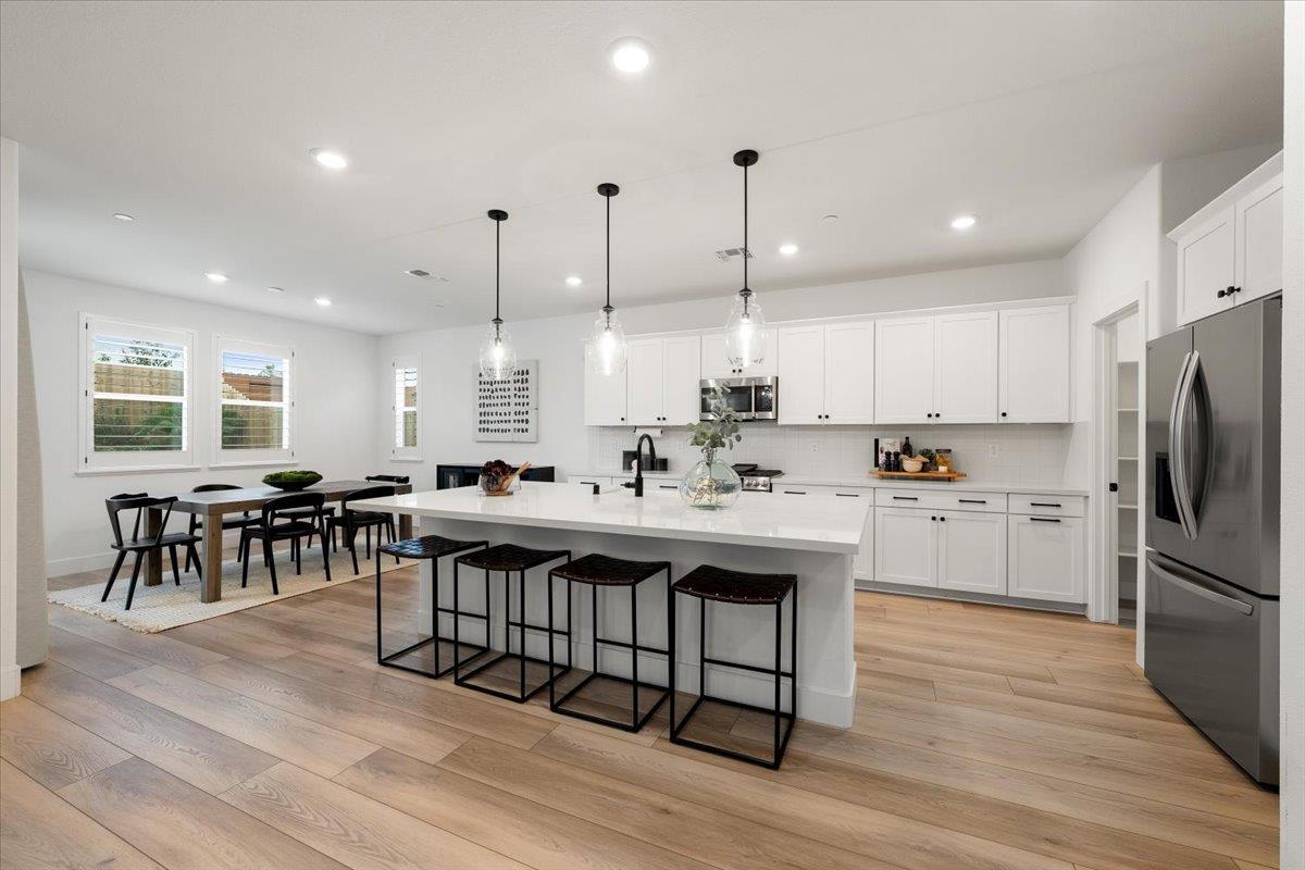 280 Vectra Court Roseville, CA 95747 - Photo 3 of 84 a kitchen with stainless steel appliances granite countertop a stove a sink a refrigerator and white cabinets with wooden floor