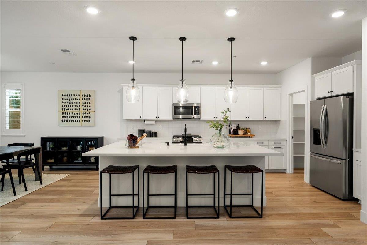 280 Vectra Court Roseville, CA 95747 - Photo 4 of 84 a kitchen with stainless steel appliances granite countertop a kitchen island hardwood floor sink stove dining table and chairs