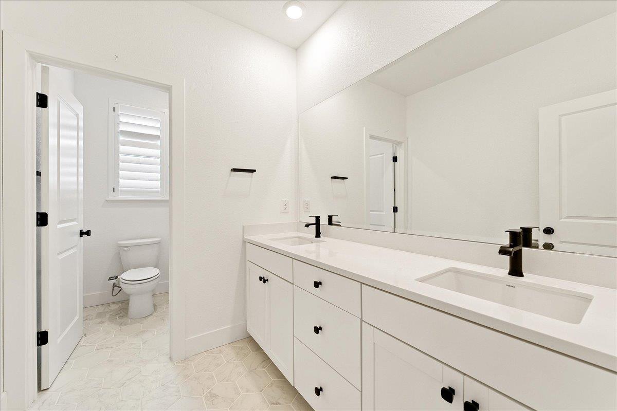 280 Vectra Court Roseville, CA 95747 - Photo 58 of 84 a bathroom with a toilet a sink a mirror and a shower