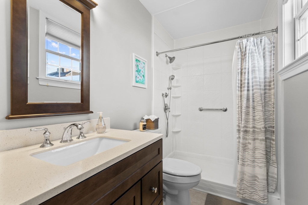 34 H Street, Unit 2L Boston, MA 02127 - Photo 16 of 20 a bathroom with a granite countertop sink toilet and shower