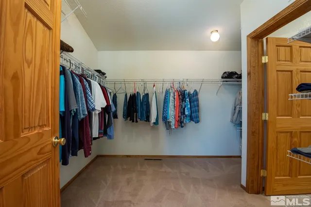 a view of walk in closet with clothes