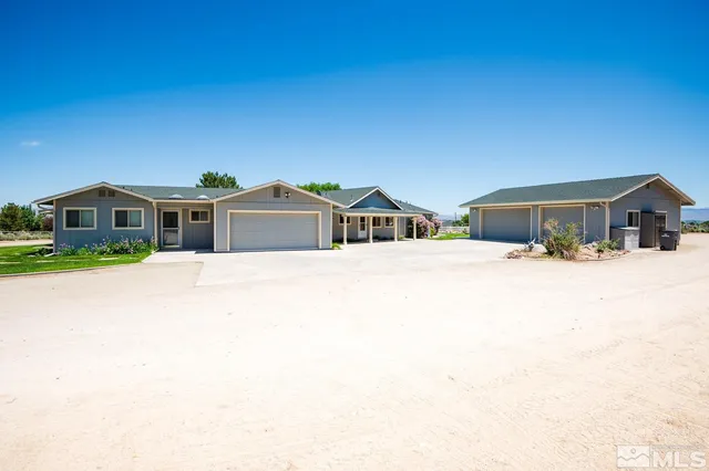 a front view of a house with large trees