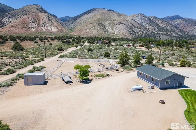 an aerial view of a house with a mountain