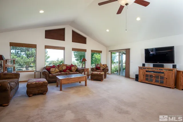 a living room with furniture flat screen tv and a large window