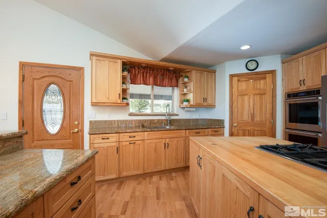 a kitchen with stainless steel appliances granite countertop a stove a sink and a microwave