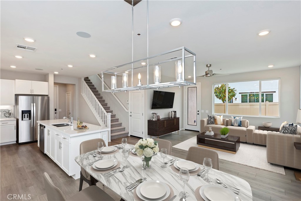 a living room with furniture kitchen view and a large window