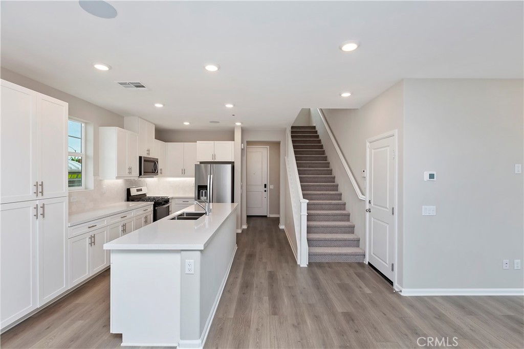 7179 Rindle Lane Riverside, CA 92503 - Photo 12 of 21 a view of a kitchen with wooden floor and electronic appliances