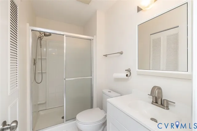 a bathroom with a toilet sink vanity and shower