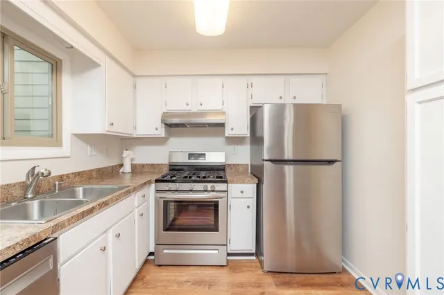 a kitchen with a stove sink and refrigerator