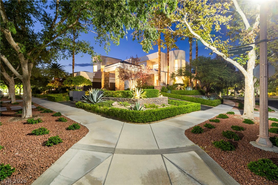 2000 Grouse Street Las Vegas, NV 89134 - Photo 69 of 89 Showcasing a grand entrance, this property features meticulously landscaped gardens and inviting walkways under elegant evening illumination.