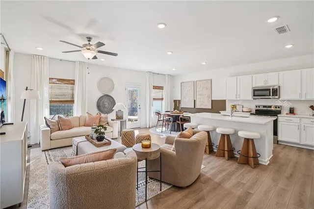 a living room with lots of furniture and kitchen view