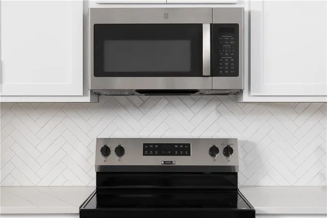 a kitchen with a refrigerator a stove a sink dishwasher a dining table and chairs with wooden floor