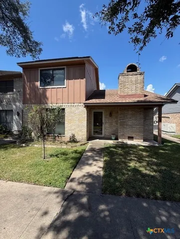 a front view of a house with a garden and plants