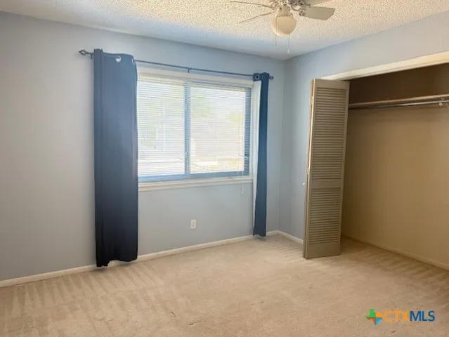 an empty room with windows and closet