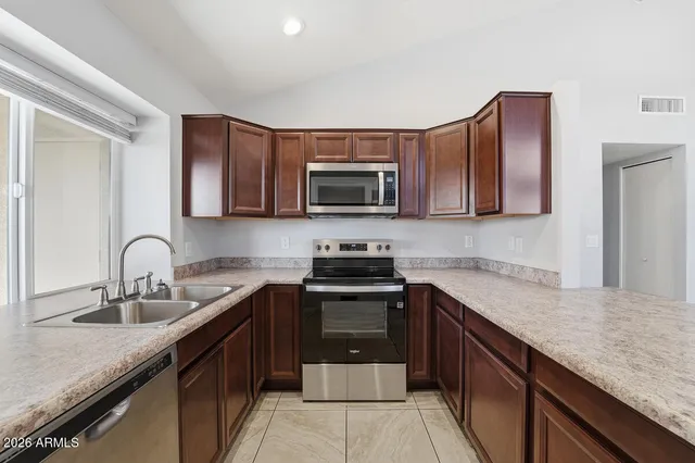 a kitchen with stainless steel appliances granite countertop a sink stove and microwave